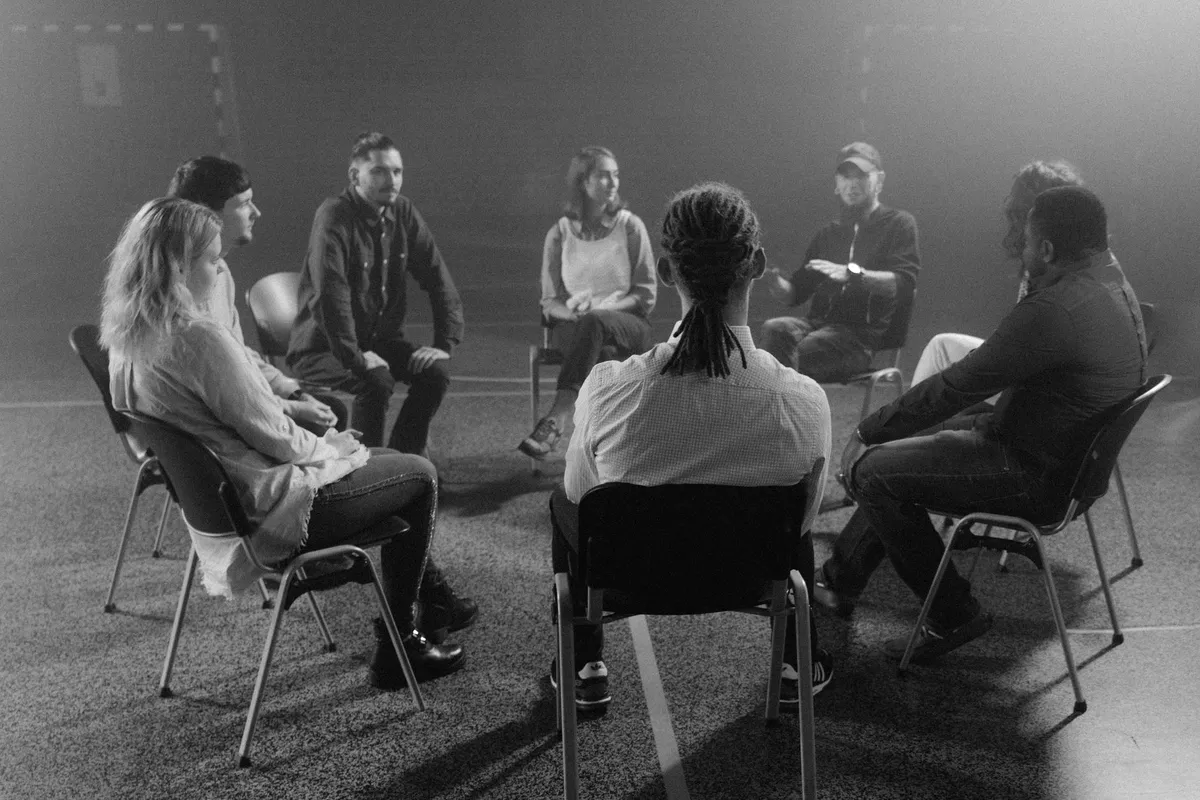 A support group sitting in a circle during a counseling session