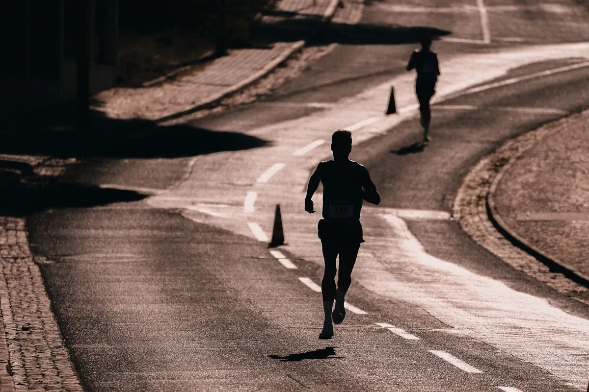 A runner training on an empty road at dawn, the same steady process that rebuilds trust in a relationship