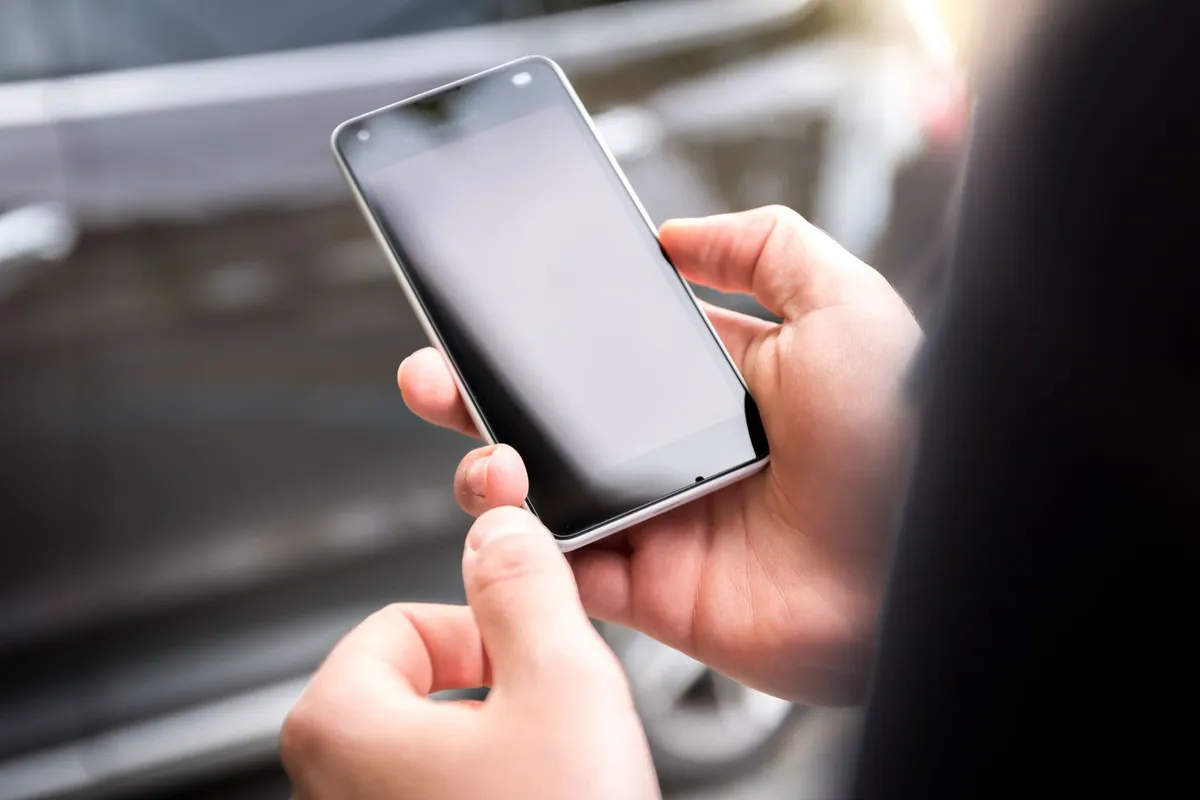 Hands changing settings on a smartphone to block porn on a phone