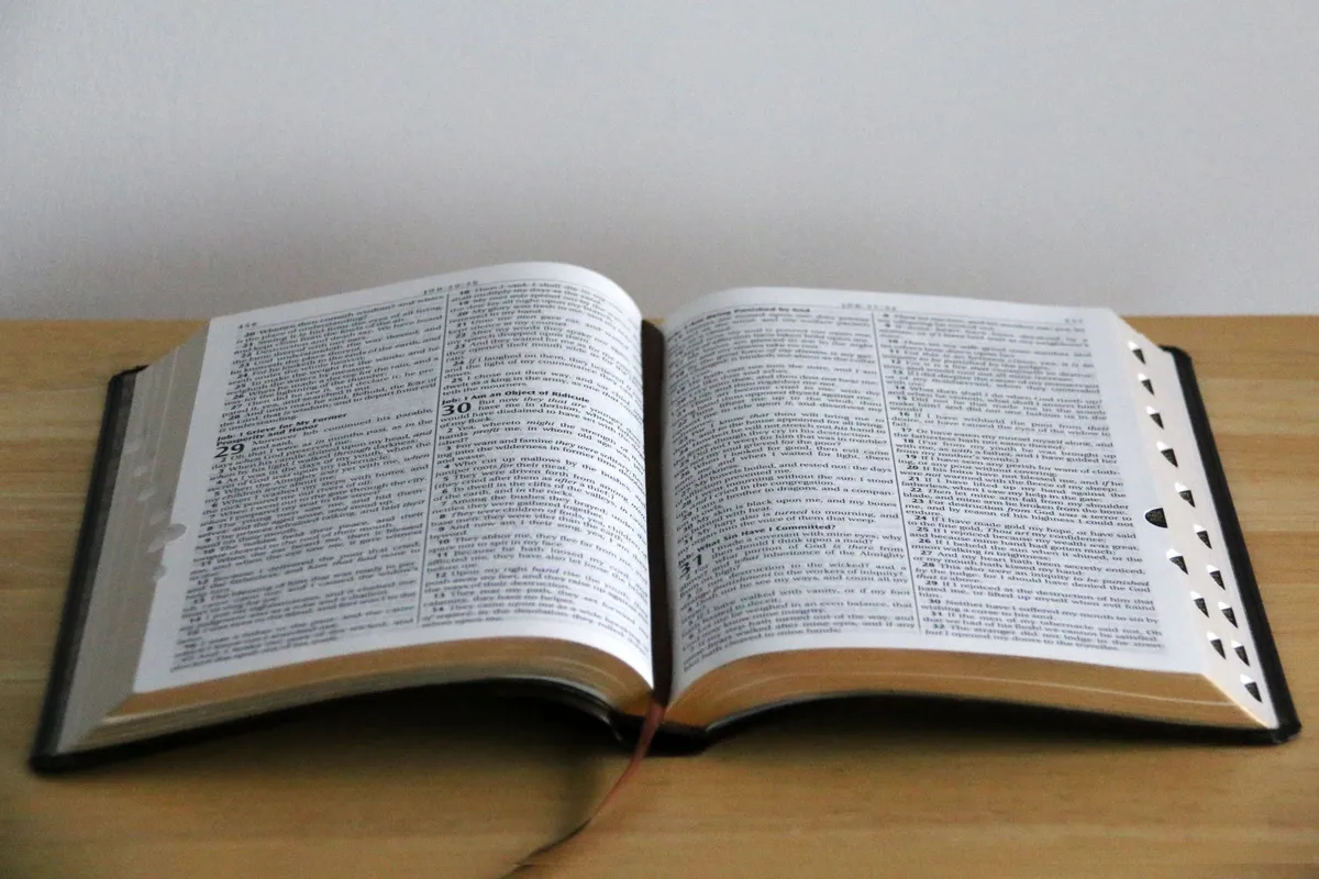 An open Bible lying on a plain wooden table