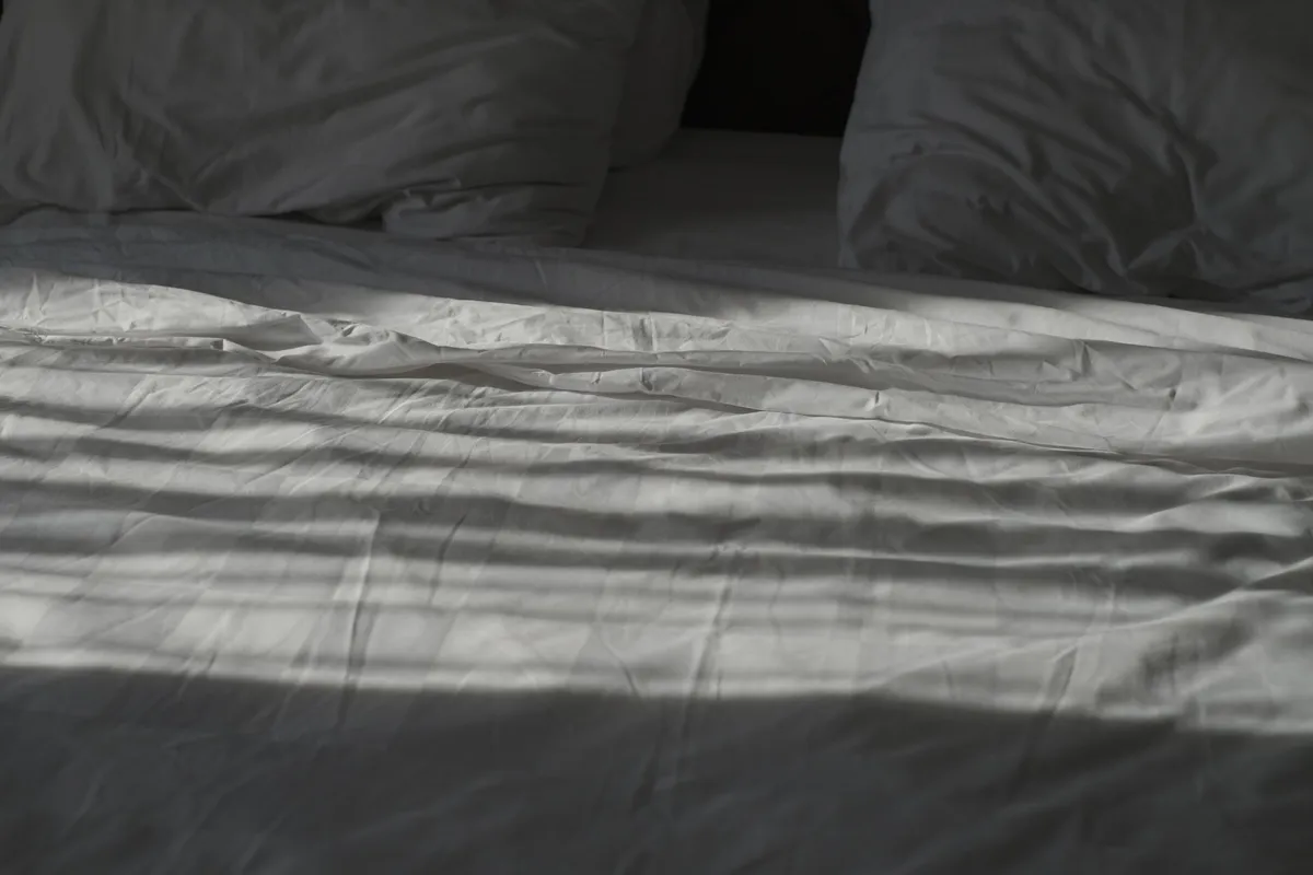 An empty unmade bed in morning light, the quiet of a lack of intimacy in marriage