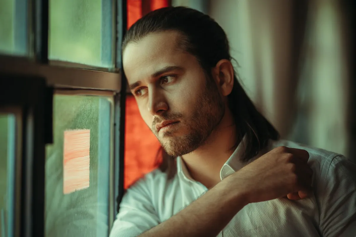 A man sitting alone in thought, considering pornography and sex addiction treatment