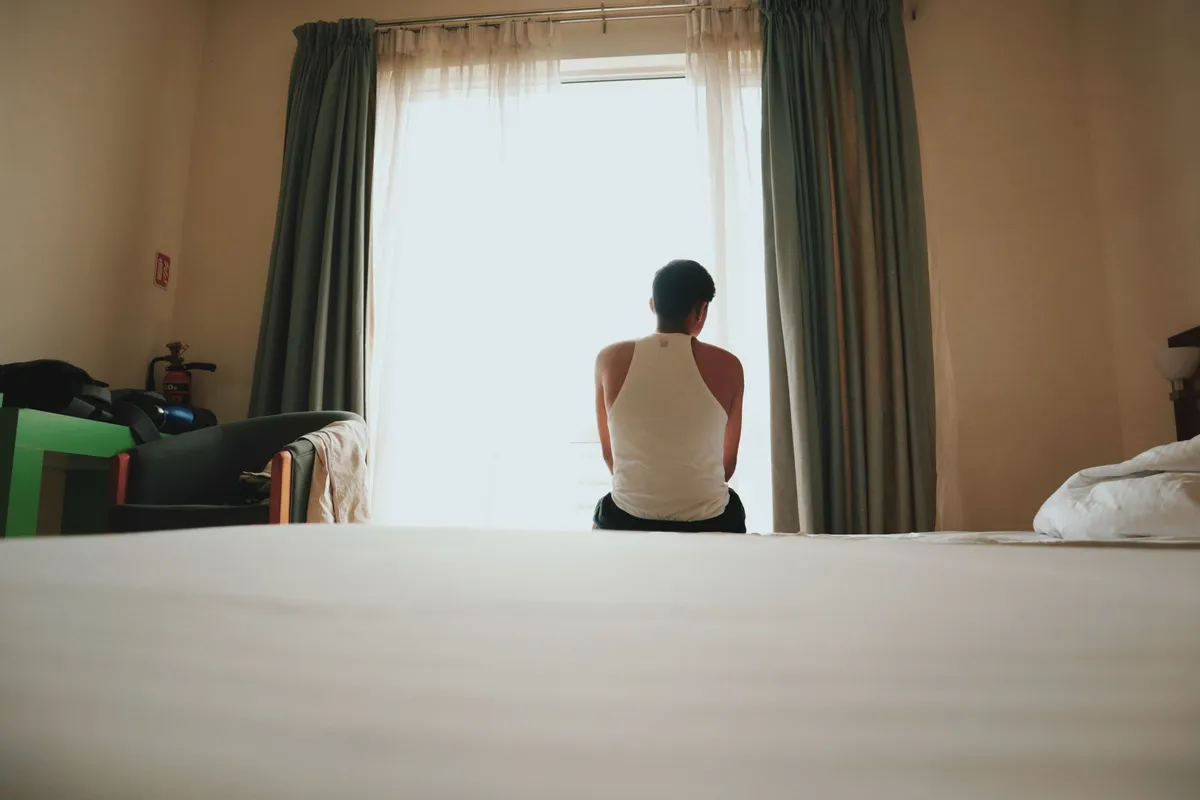 A man sitting alone in the morning light, thinking about how to rebuild trust after cheating