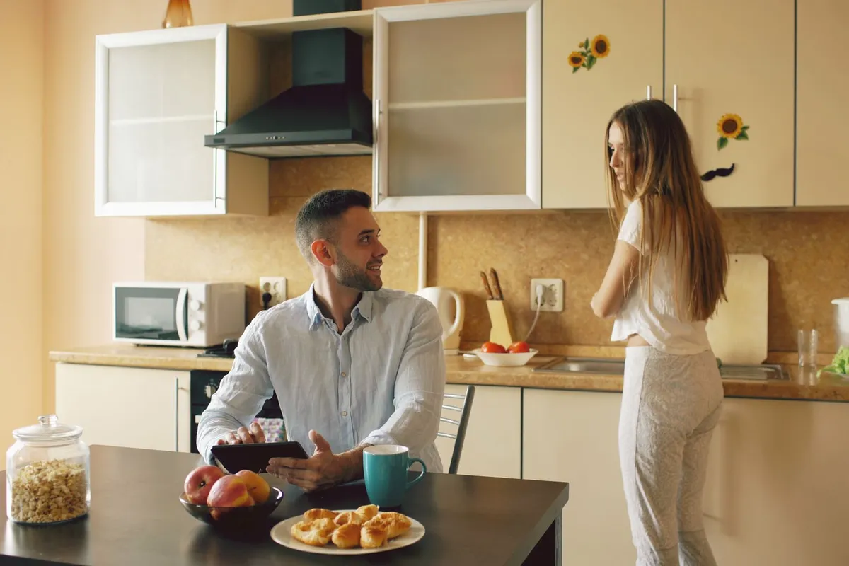 A couple having an honest conversation at a kitchen table, working on how to rebuild trust in a relationship