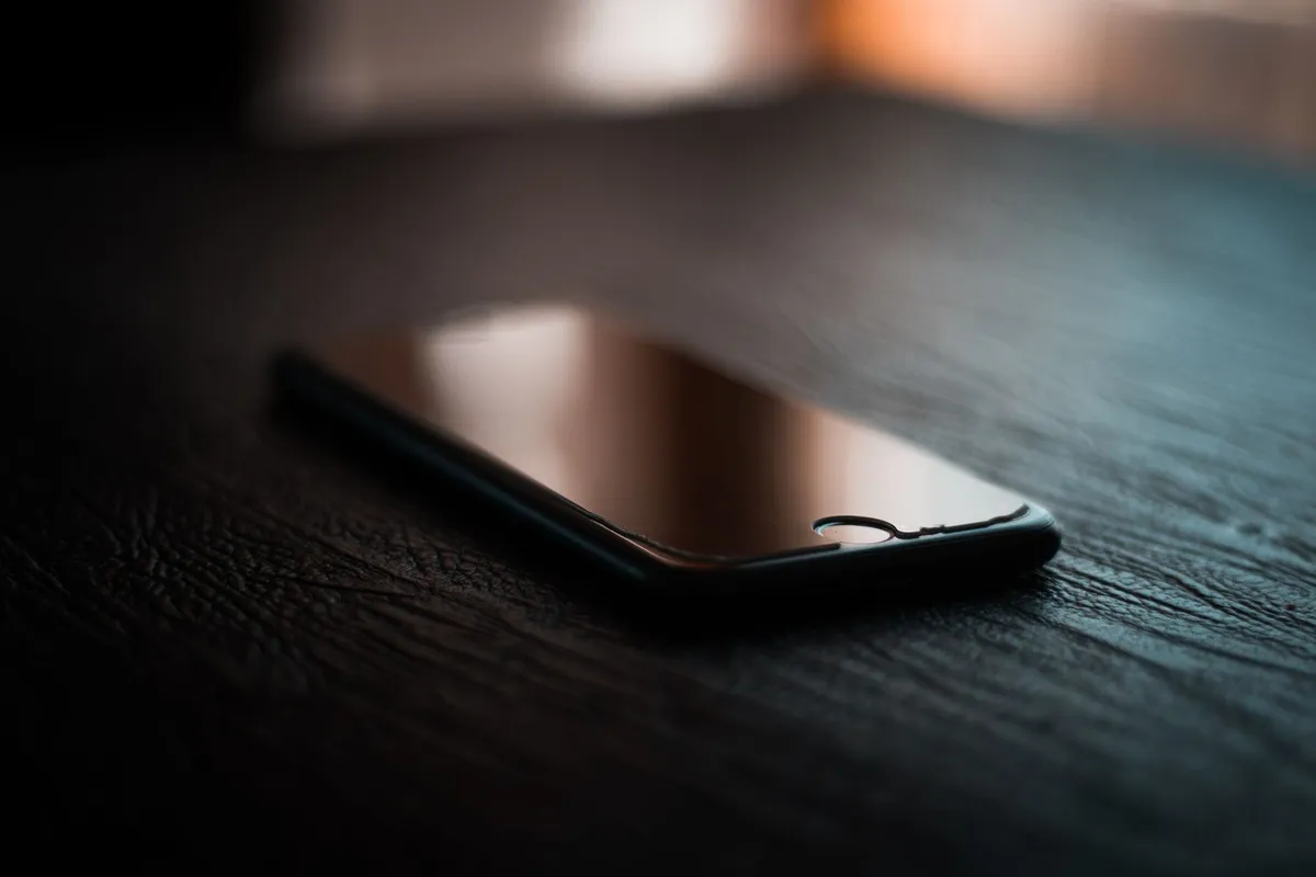 A phone lying face down on a table, one of the most common signs of a cheating husband