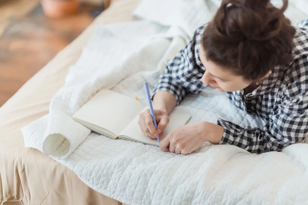 A woman journaling as part of recovery with a therapist for betrayal trauma